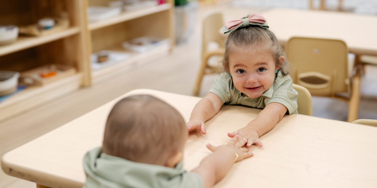 children smiling and playing together in a Montessori classroom